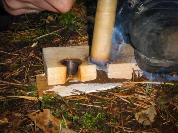 Holzstück mit Bohrer erzeugt Rauch und Glutnest