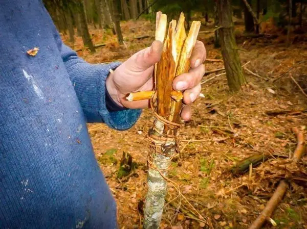 Selbstgebaute Konstruktion aus Ästen, mit Schnur zusammengebunden, in Hand gehalten