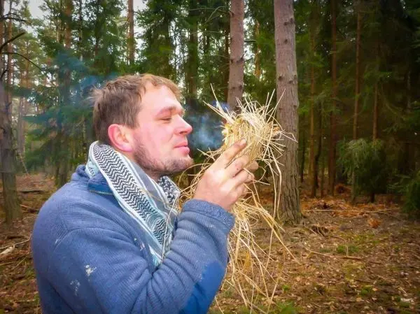 Zunder glimmt in den Händen, Rauch steigt auf