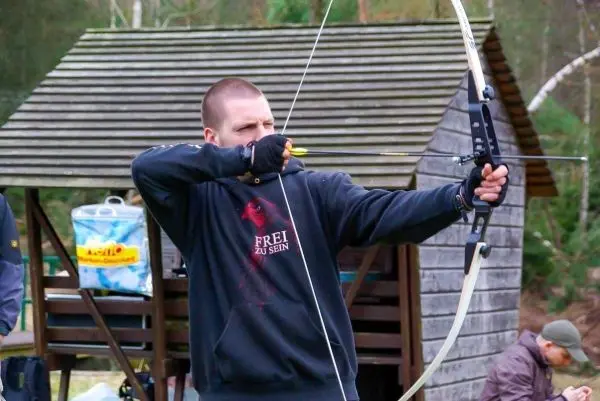 Bogen wird gespannt, Pfeil zielt auf ein Ziel