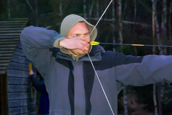 Bogen wird gespannt, Pfeil zielt auf ein Ziel