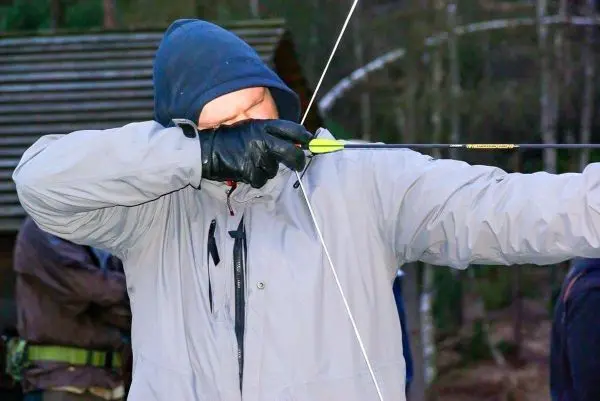 Bogen wird mit Pfeil gespannt und auf Ziel ausgerichtet
