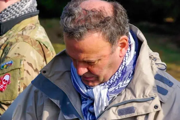 Es sind zwei Personen in Outdoor-Bekleidung zu sehen, eine schaut nach unten