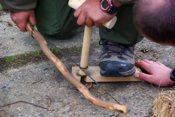 Feuerbohrer wird mit einem Holzstück und einer Schnur betrieben