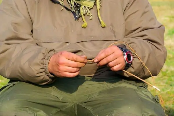 Hände formen einen Zunder aus einer Pflanze