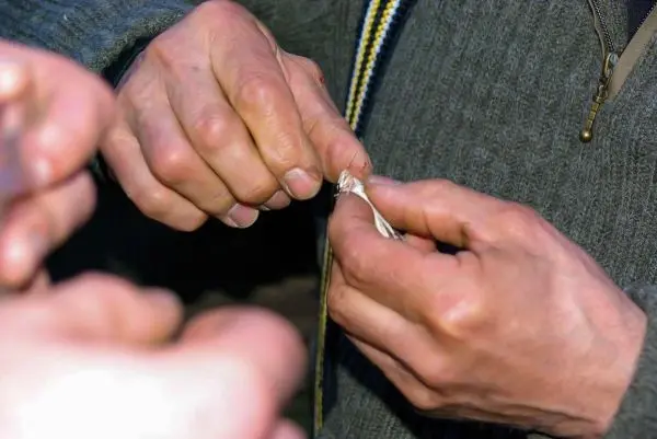 Hände knoten ein Seil zusammen