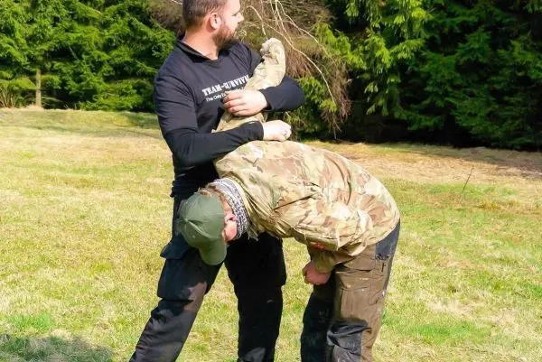 Kampftechniken werden demonstriert, während eine Person kontrolliert wird