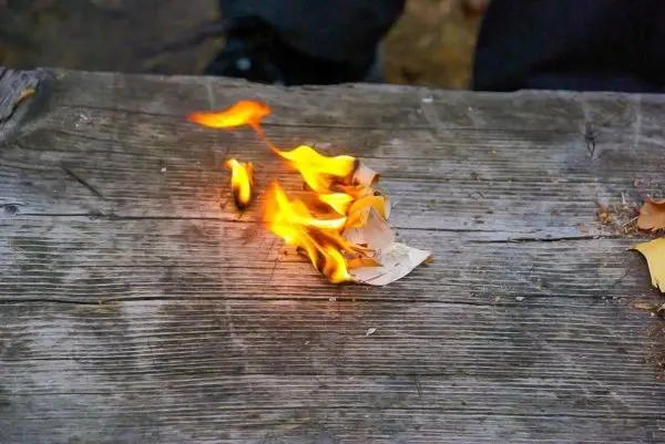 Kleine Flamme brennt auf einem Holzbrett