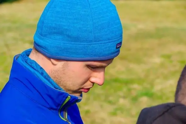 Mann mit blauer Mütze und Jacke schaut nach unten