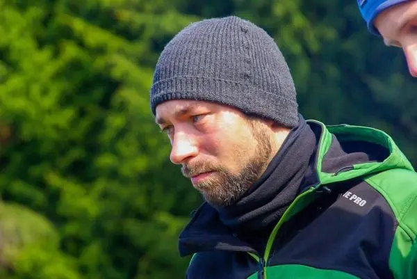 Person trägt eine Mütze und schaut nachdenklich zur Seite