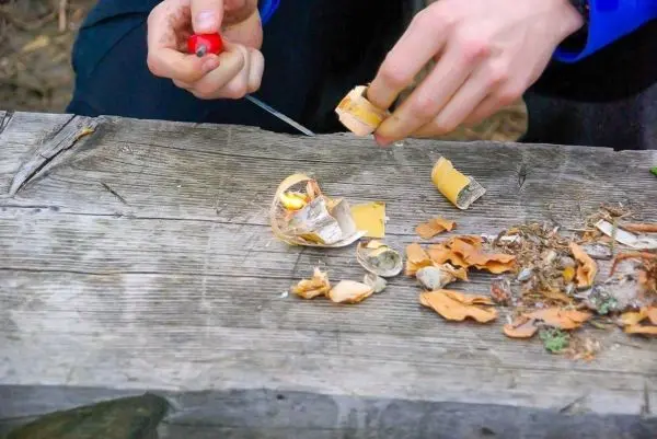 Zunder wird mit einem Feuerzeug entzündet
