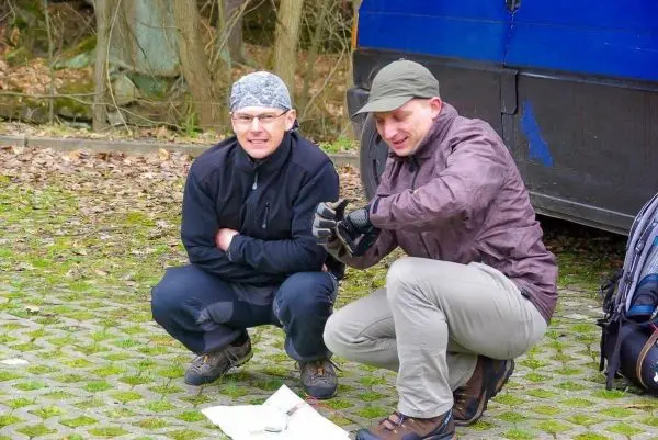 Zwei Personen hocken auf dem Boden und betrachten eine Karte