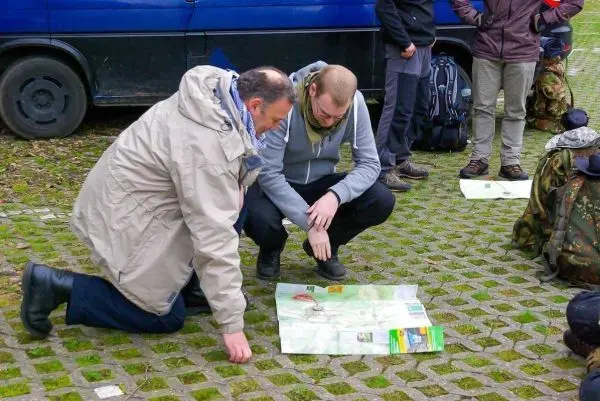 Zwei Personen knien auf dem Boden und studieren eine Karte