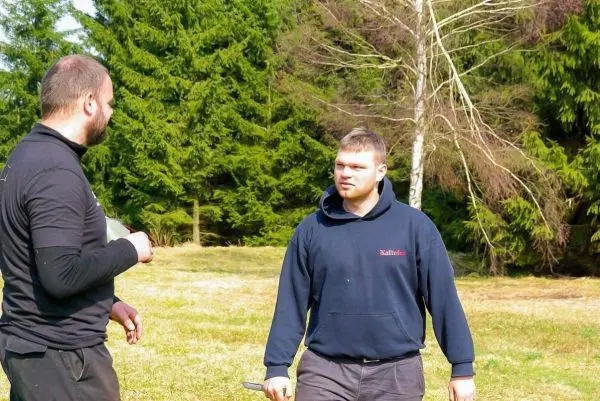 Zwei Personen stehen auf einer Wiese und unterhalten sich