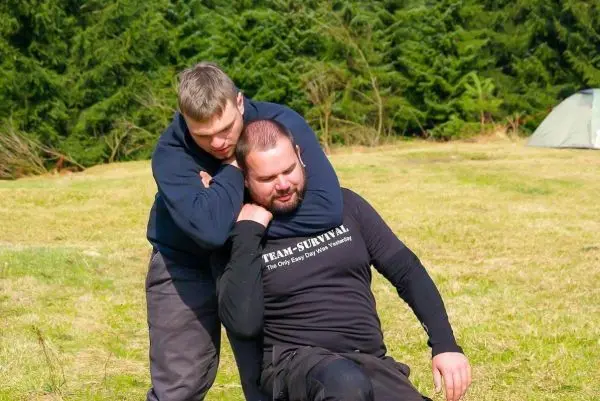 Zwei Personen üben eine Selbstverteidigungstechnik im Freien