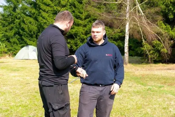 Zwei Personen üben eine Technik mit einem Seil im Freien