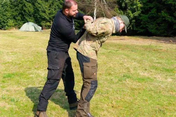 Zwei Personen üben eine Technik zur Kontrolle des Gegners im Freien