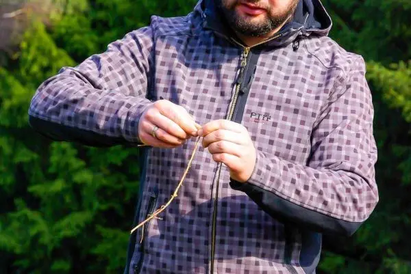 Zweig wird mit beiden Händen bearbeitet und vorbereitet