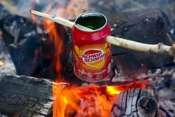 Dose über dem Feuer auf einem Stock zum Erhitzen platziert