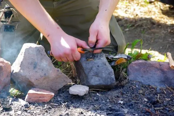 Feuerstahl erzeugt Funken auf Zunder zwischen zwei Steinen