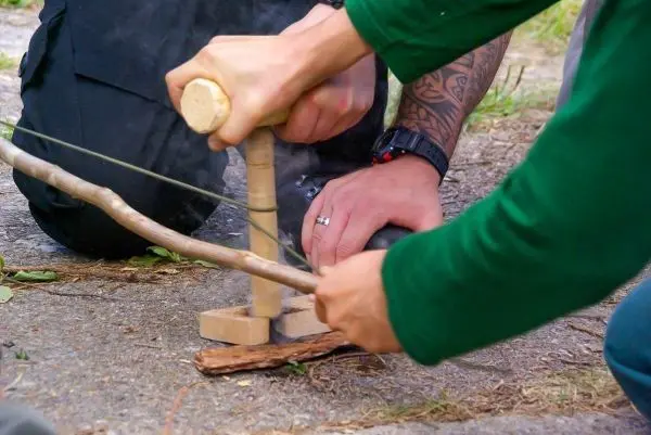 Holzbohrer erzeugt Rauch durch Reibung auf einem Holzstück