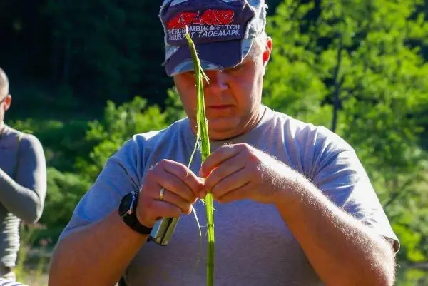Mann formt einen langen Zweig mit beiden Händen