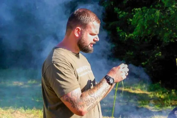 Mann hält Schnur in der Hand, Rauch umgibt ihn