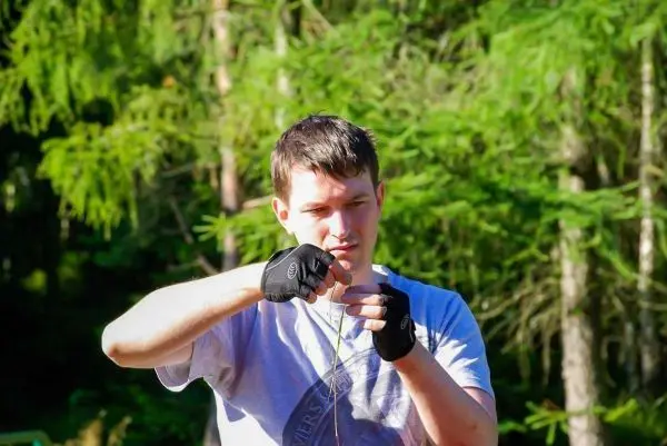 Mann mit Handschuhen hält eine Schnur und konzentriert sich auf die Handhabung