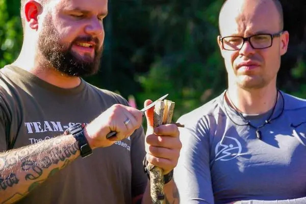 Messer schneidet Holzstück zur Vorbereitung für Zunder