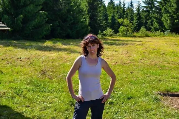 Person steht auf einer wiese und laechelt