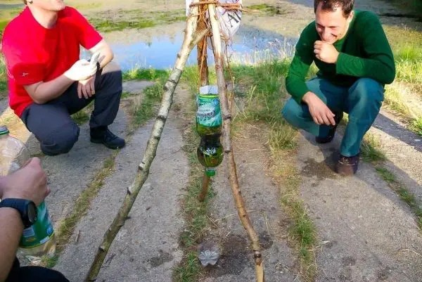 Selbstgebaute Konstruktion aus Ästen mit hängendem Behälter für Wasser