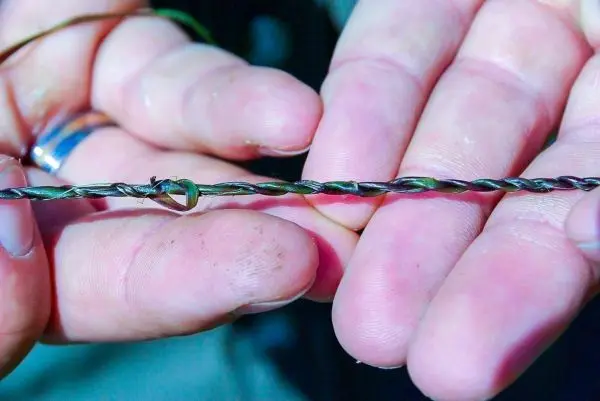 Draht mit einer Schlaufe wird zwischen zwei Fingern gehalten