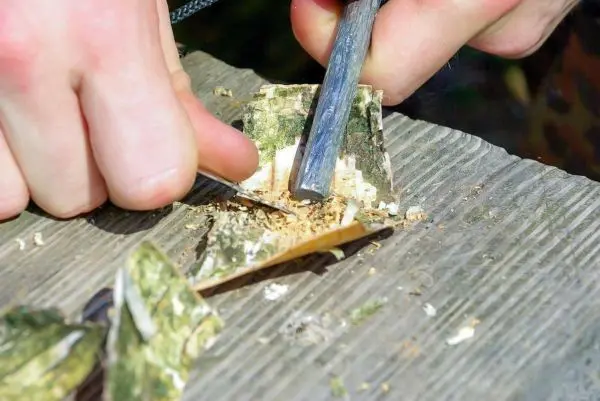 Feuerstahl erzeugt Funken auf Zunderstück aus Rinde