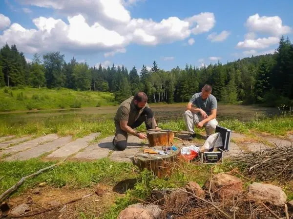 Zwei Personen arbeiten an einem Baumstumpf mit Werkzeugen und Materialien