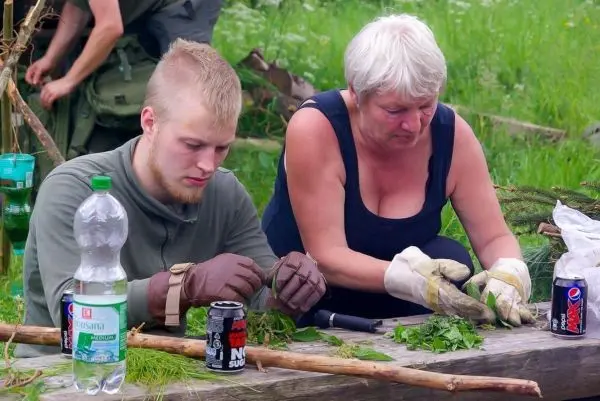 Zwei Personen schneiden Pflanzenmaterial auf einem Tisch, daneben Getränke und Werkzeuge