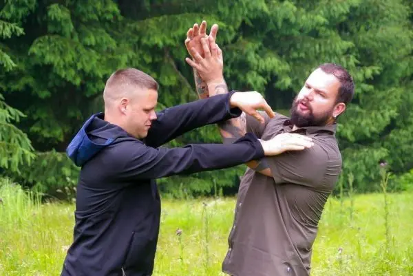 Zwei Personen üben eine Selbstverteidigungstechnik im Freien