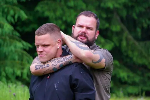 Zwei Personen üben eine Selbstverteidigungstechnik im Freien aus