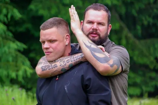 Zwei Personen üben eine Selbstverteidigungstechnik im Freien aus