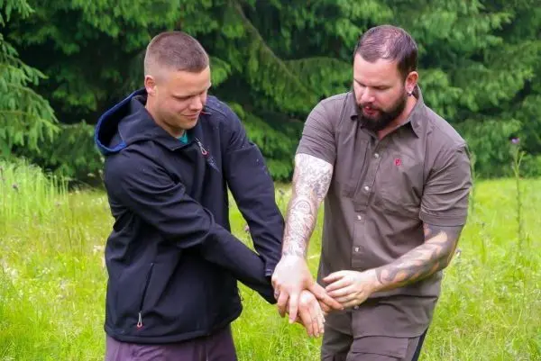 Zwei Personen üben eine Technik zur Handbefreiung im Freien