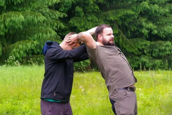 Zwei Personen üben eine Technik zur Kontrolle des Gegners im Freien
