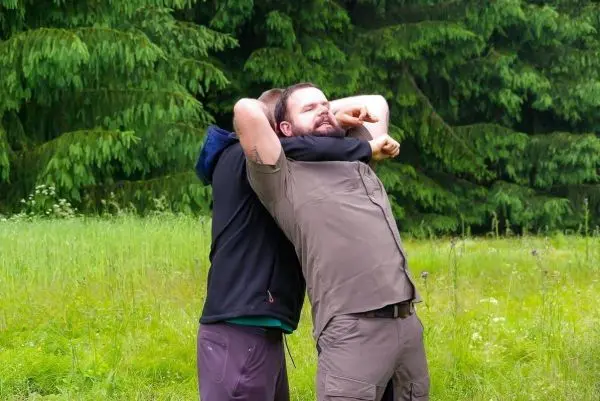 Zwei Personen üben eine Technik zur Kontrolle des Gegners im Freien aus