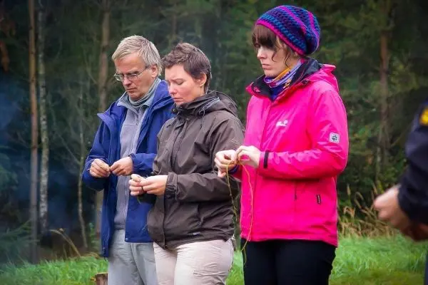Drei Personen knoten Seile in einer Waldumgebung