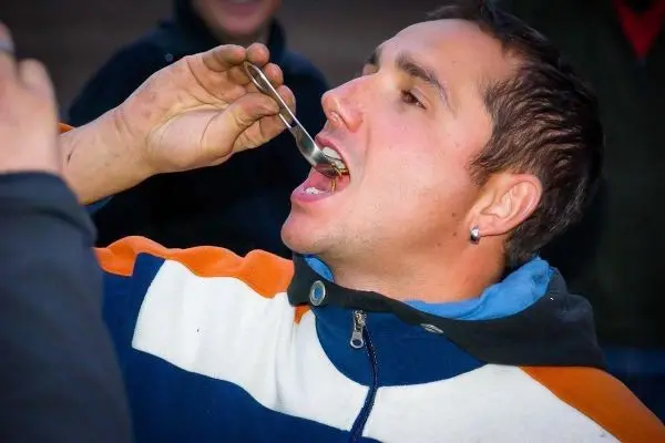 Mann hält einen Löffel an den Mund und isst etwas