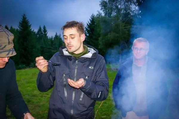 Mann hält Löffel mit Nahrung in der Hand, Rauch umgibt ihn