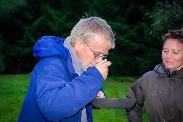 Mann isst aus einer Pfanne, während eine Frau daneben steht
