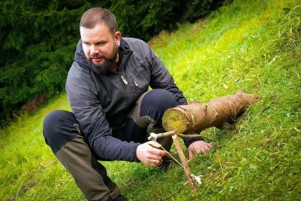 Person arbeitet an einem selbstgebauten Gerät aus Holz