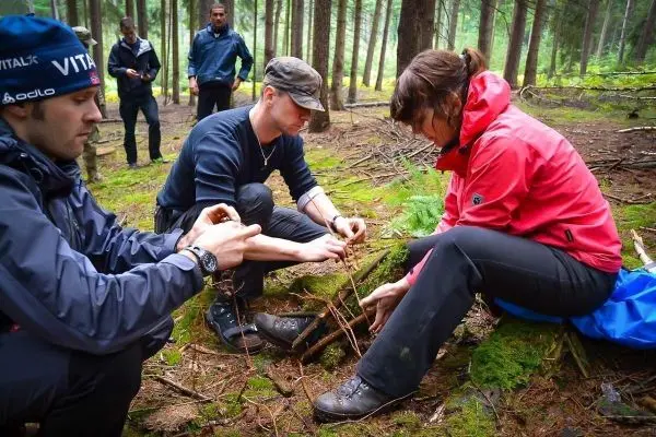 Personen bauen eine Struktur aus Ästen im Wald
