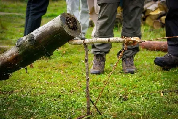 Schlagfalle (Figure-Four-Falle) mit Holzstück und Auslöser auf dem Boden