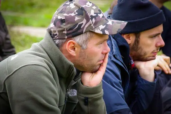 Zwei Männer sitzen nebeneinander und hören aufmerksam zu