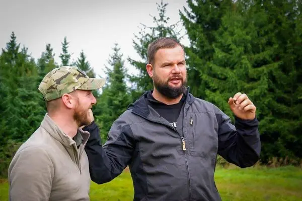 Zwei Männer stehen im Freien und diskutieren, einer gestikuliert mit der Hand
